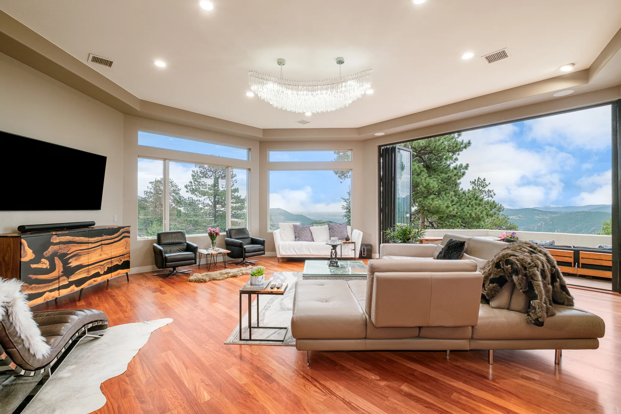 Great room with glass walls opening to expansive mountain views.