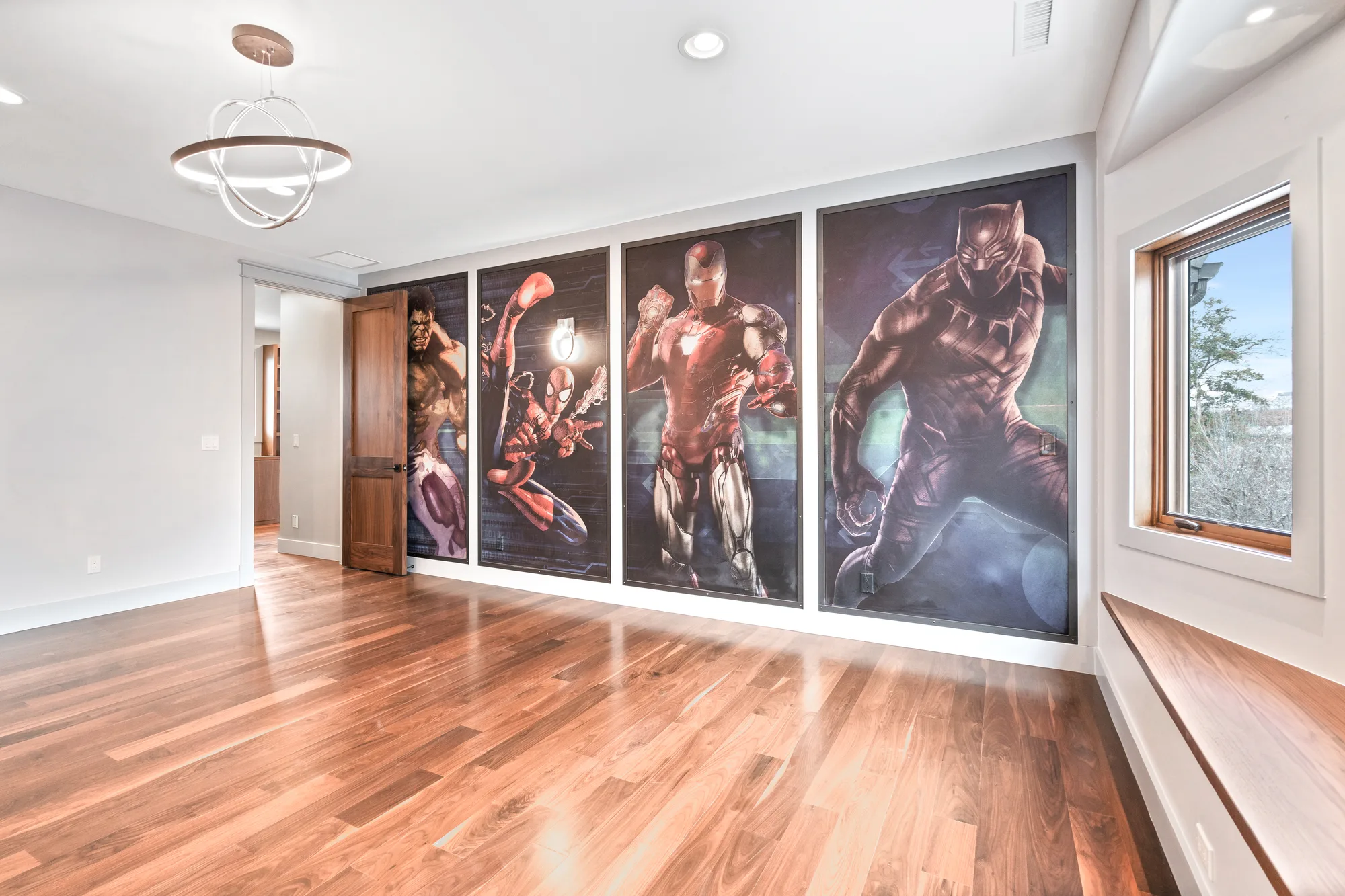 Bedroom with walnut floors, a walnut window seat, and a full-height printed mural wall