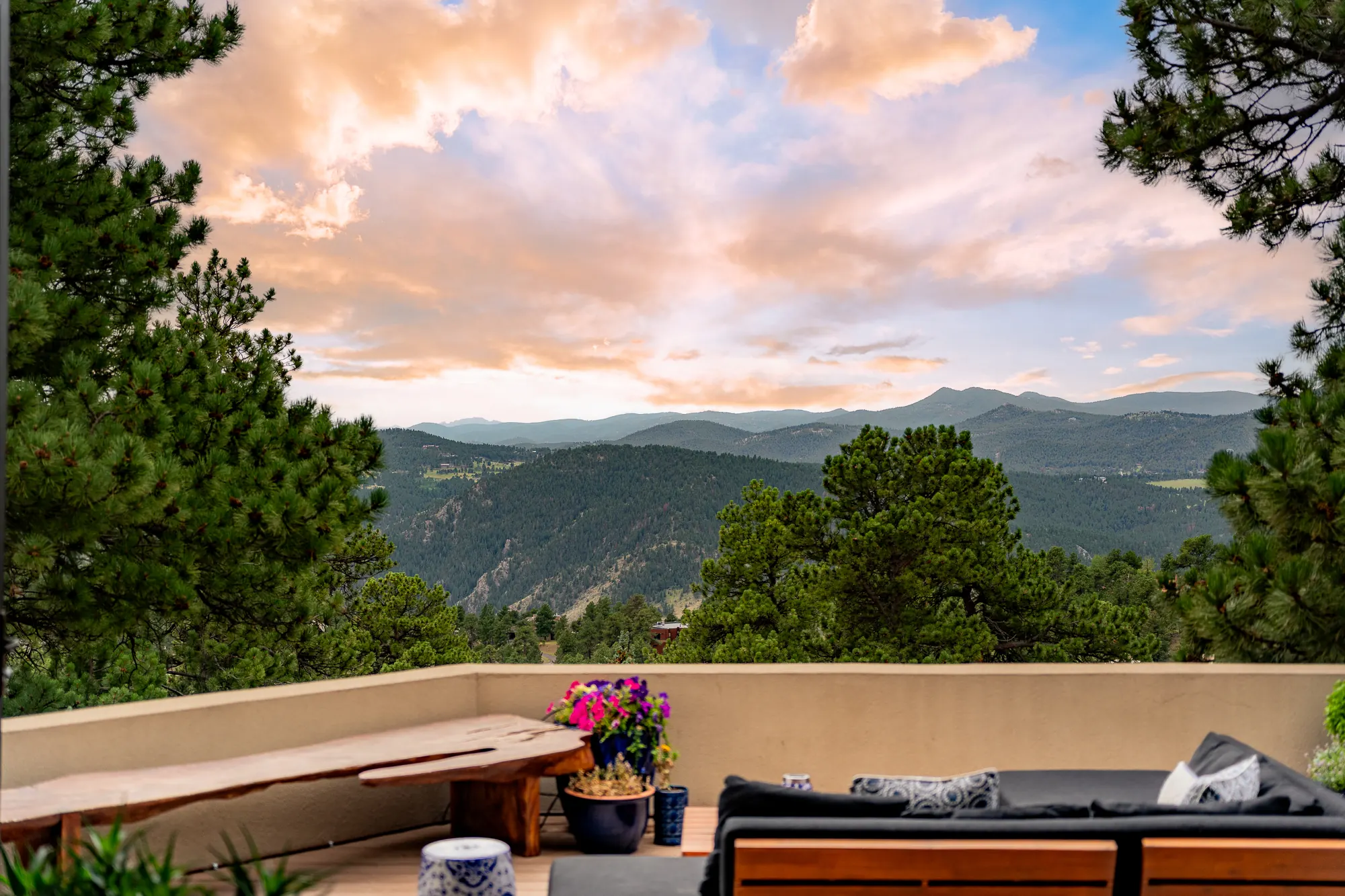 Sunset over layered forested ridges seen from the deck parapet.
