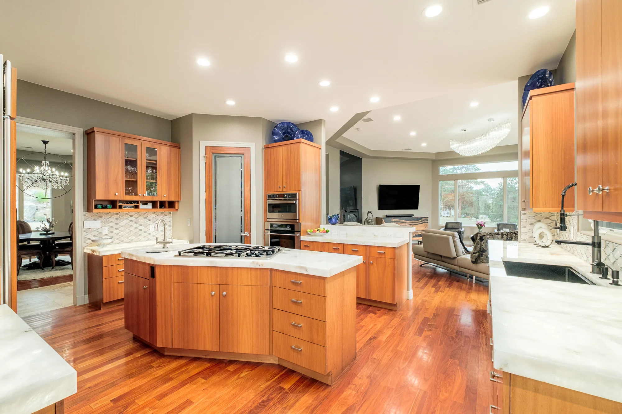 Wide view of the wood-paneled kitchen with a stone island.