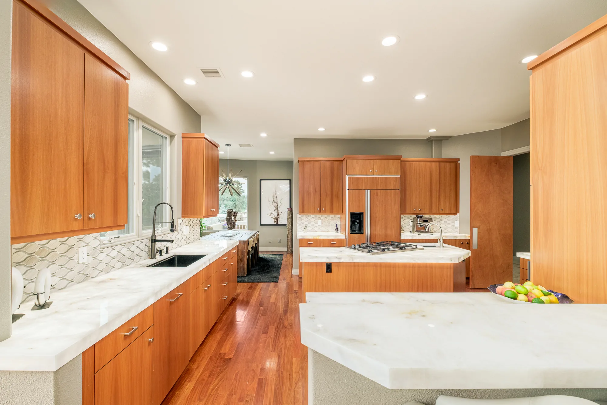 Galley run of cherry cabinets and marble counters looking through to the dining area.