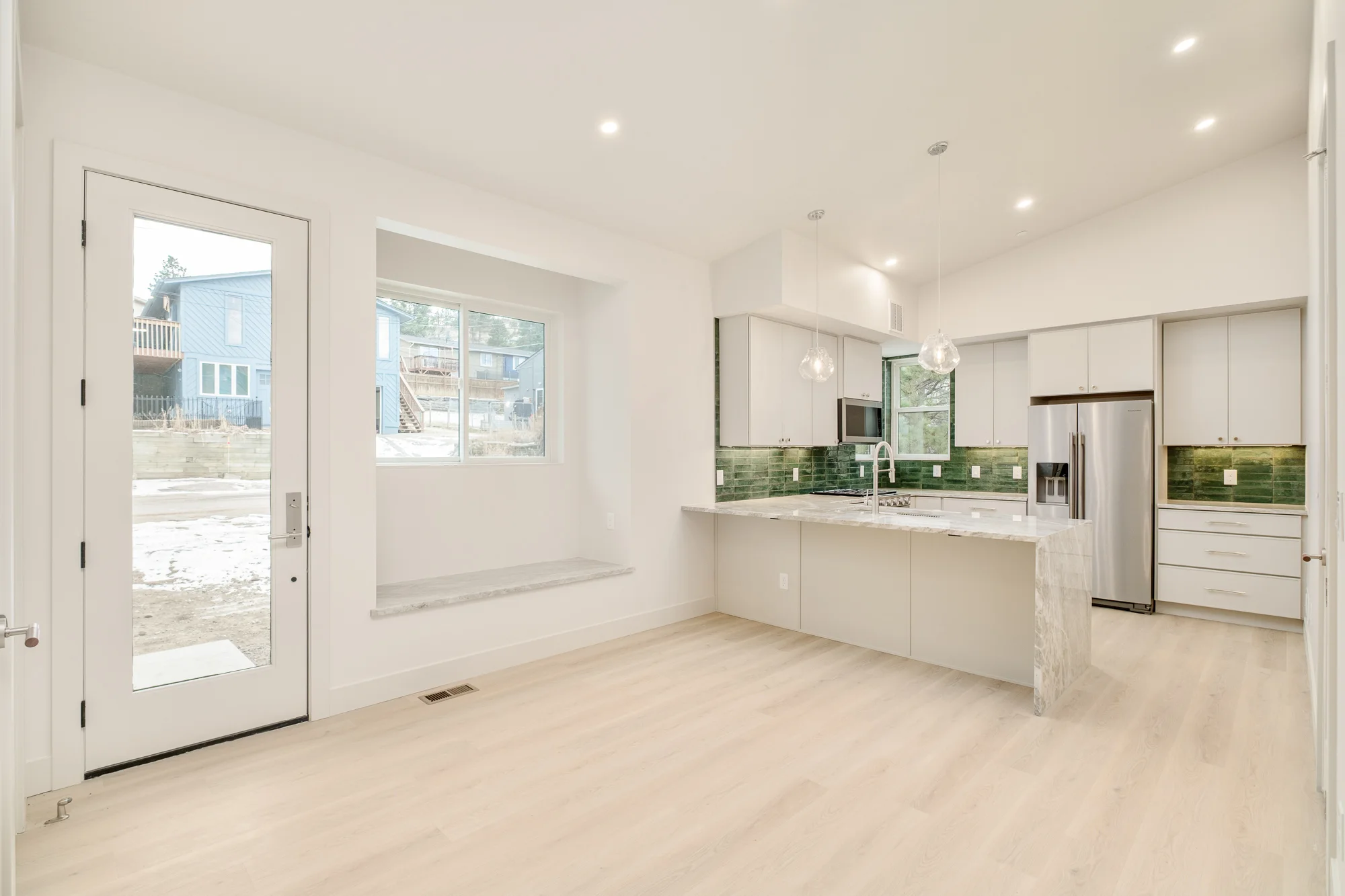 Dining area with a quartzite window seat set into the wall and a glazed door to the drive