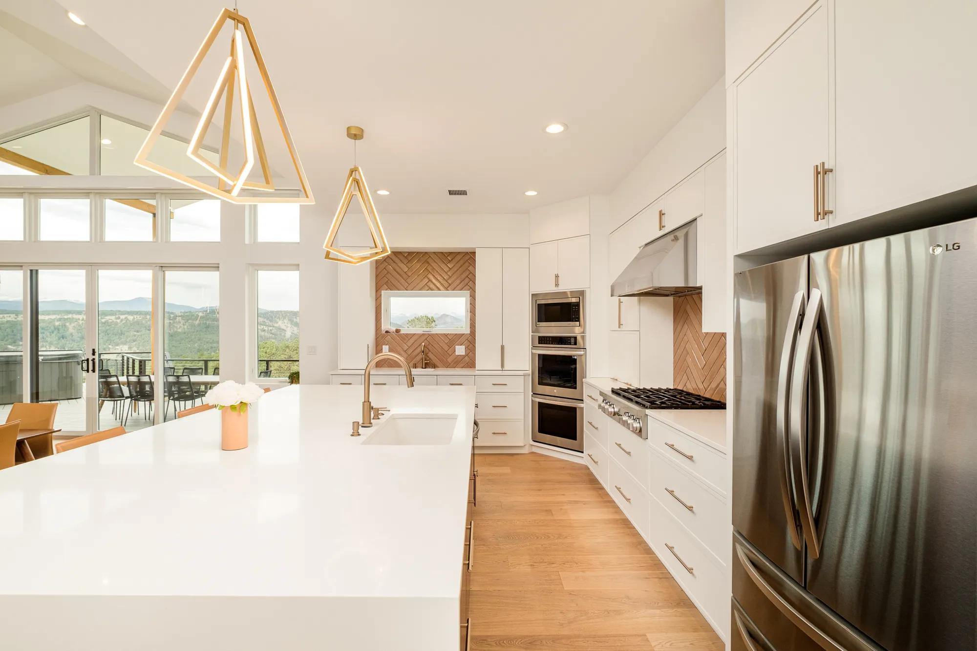 Kitchen with a waterfall island, built-in refrigerator and windows to the foothills