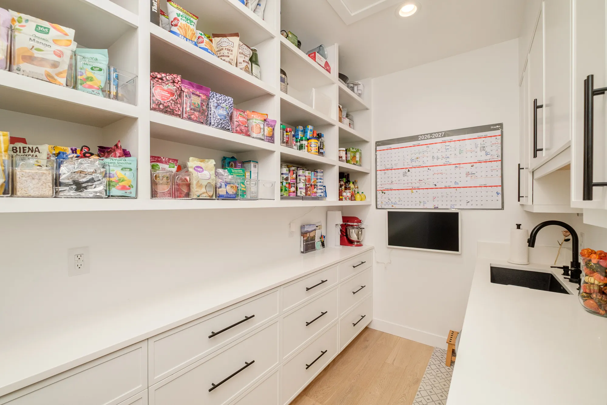 Walk-in pantry with open shelving and a prep sink