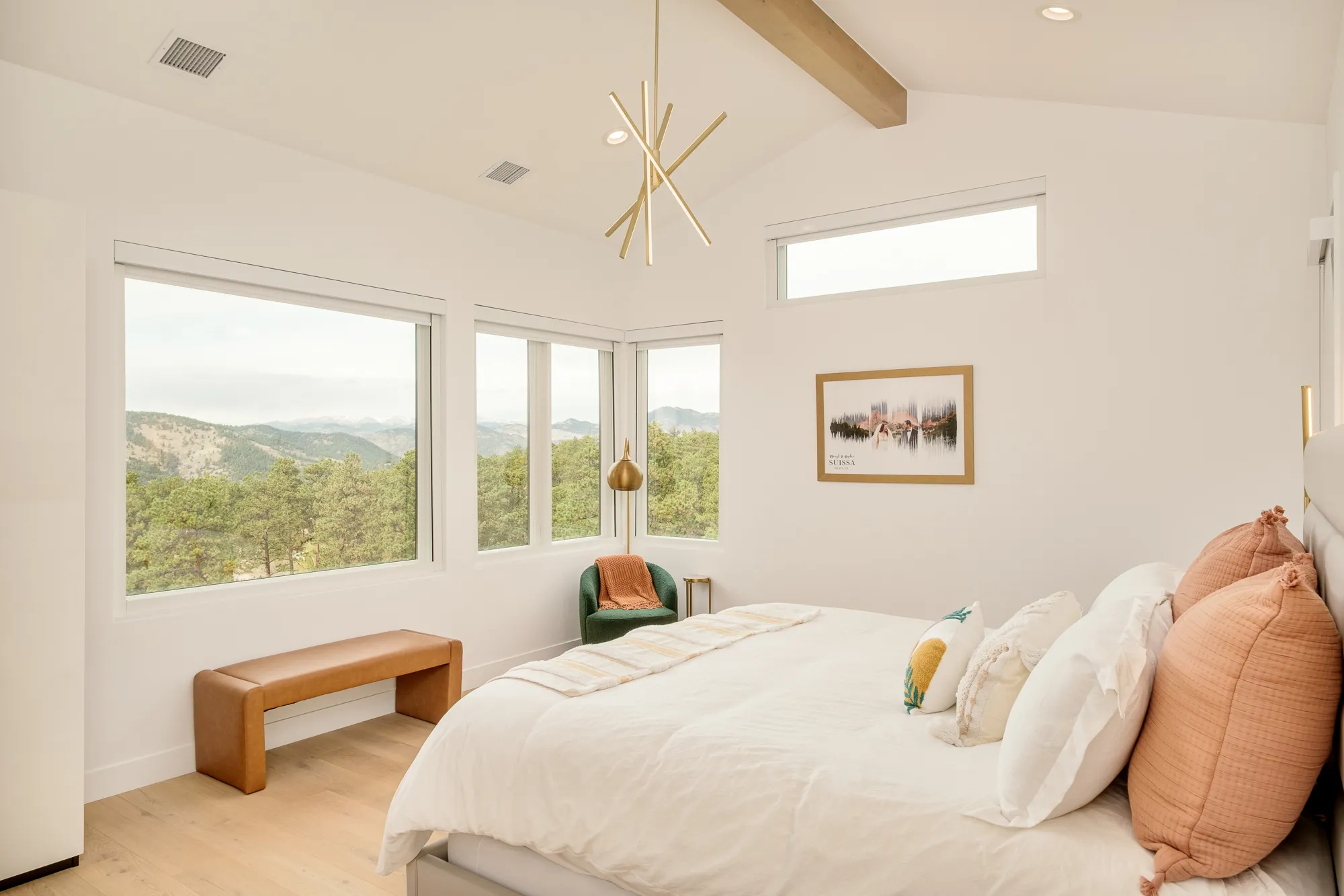 Primary bedroom with a vaulted ceiling, exposed beam and corner windows to the mountains