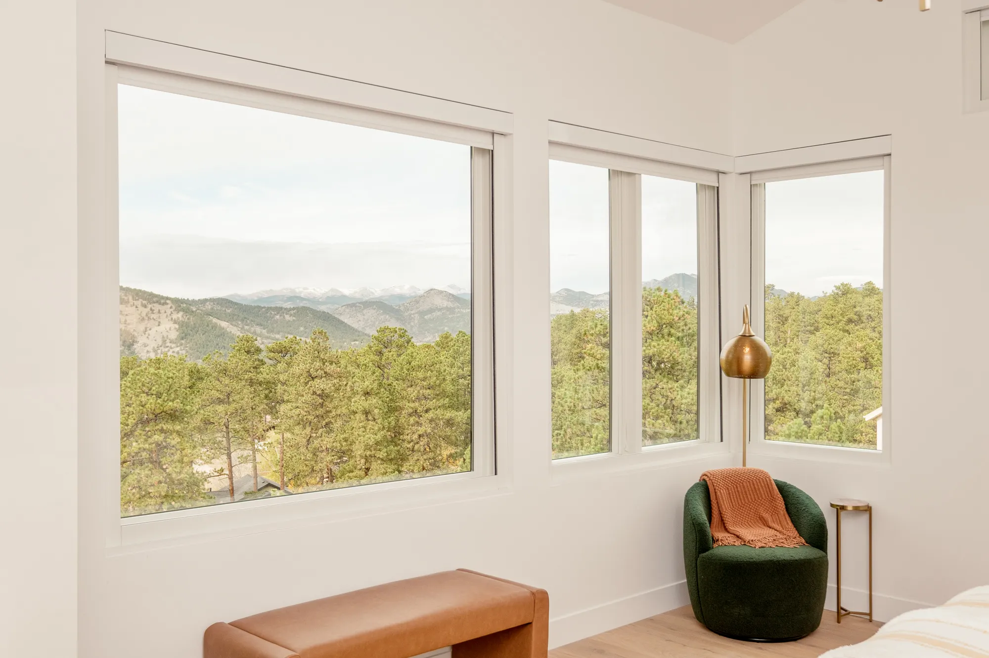 Primary bedroom windows looking out over pine-covered foothills