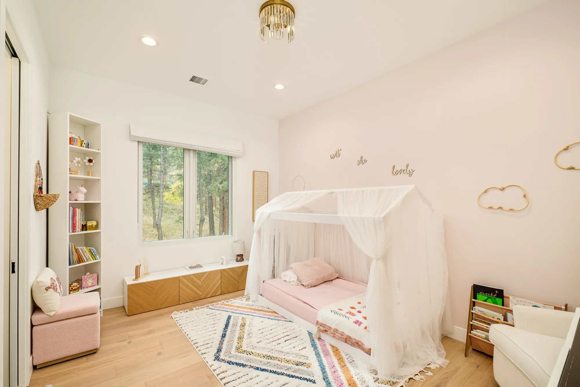 Child's bedroom with a canopy bed and built-in window seat