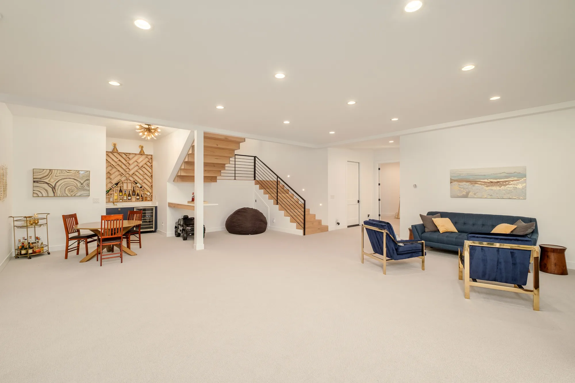 Open lower-level recreation room with an oak stair and lounge seating