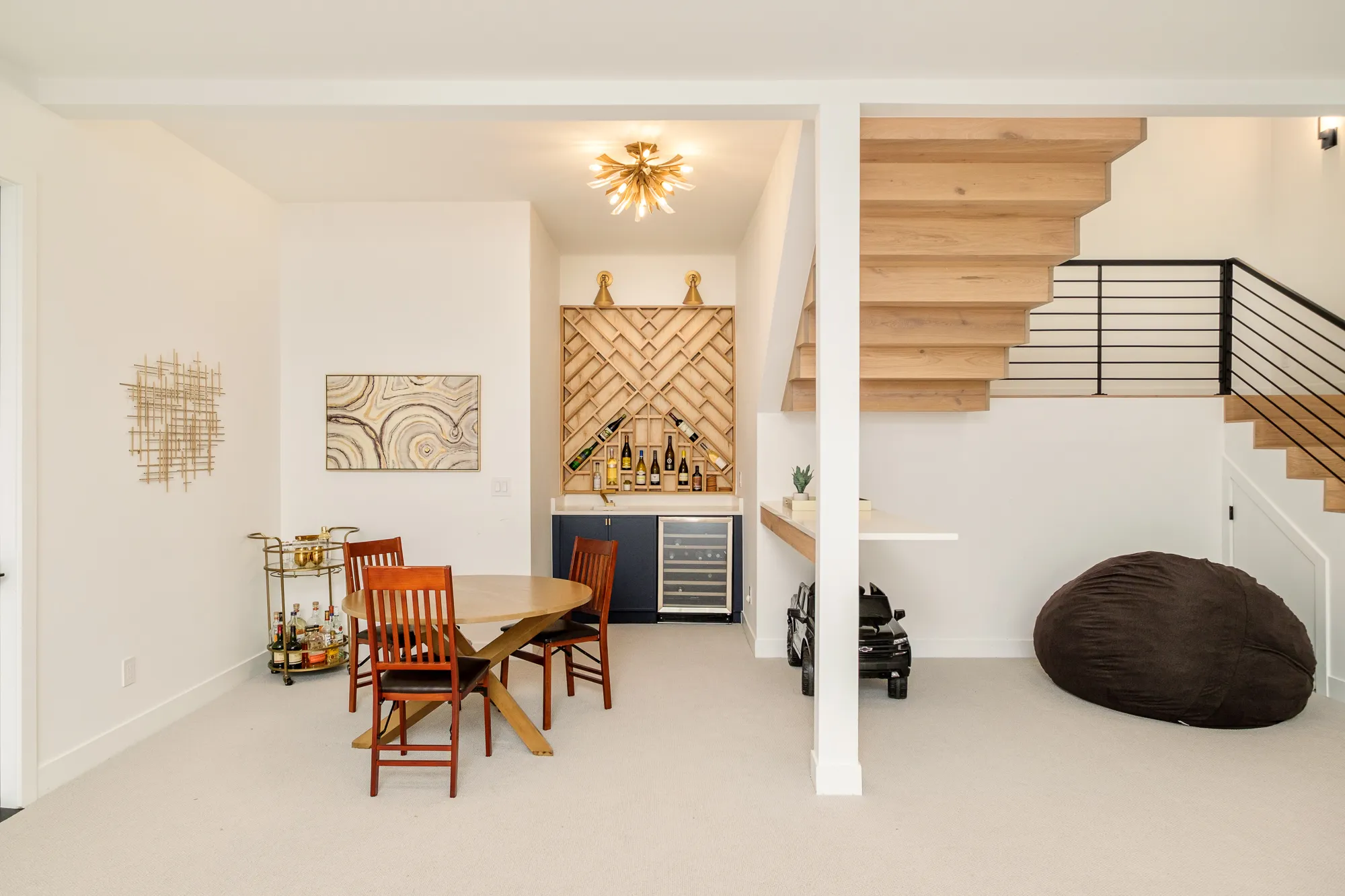 Lower-level game area with a dining table and herringbone wine wall