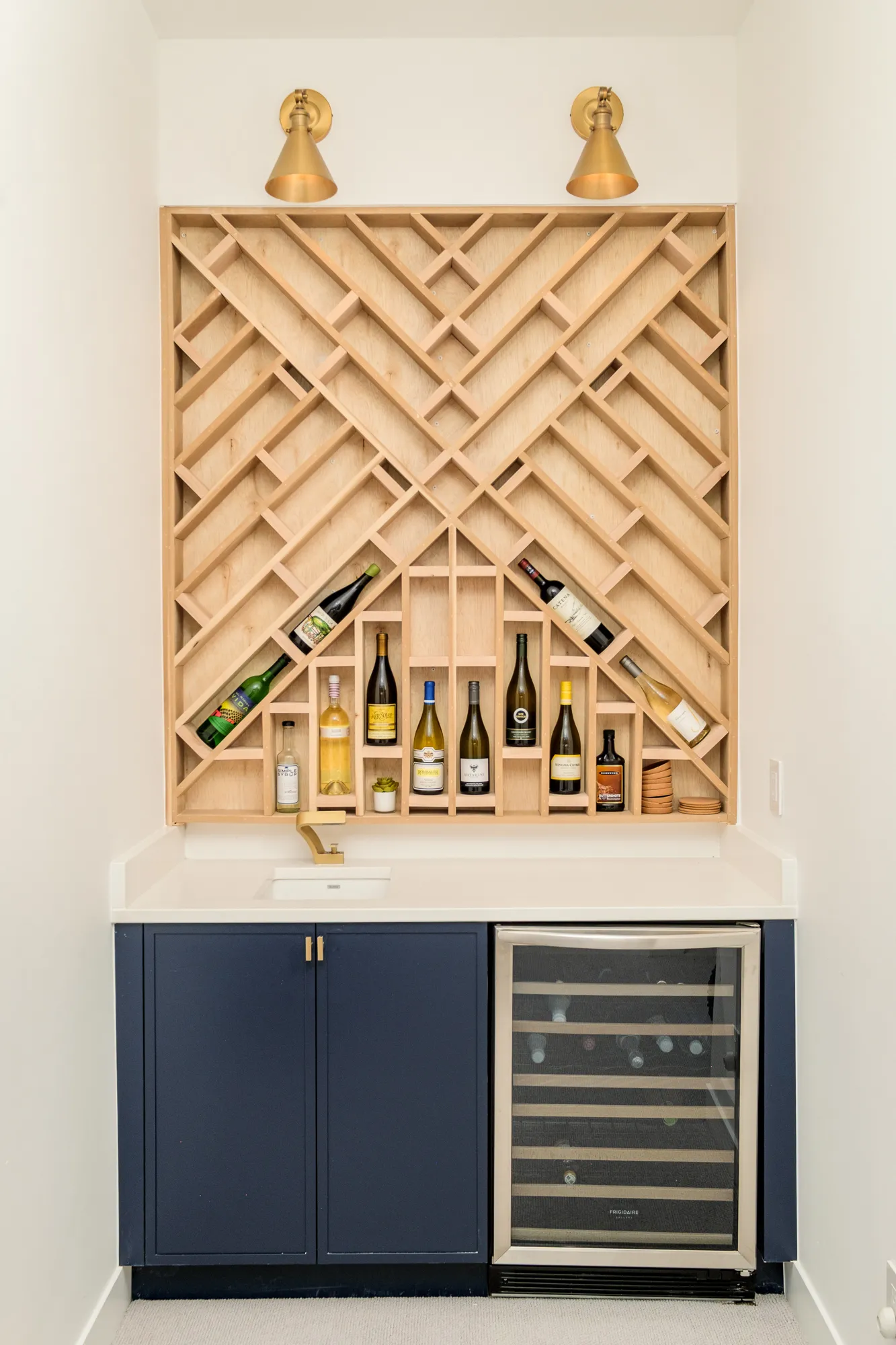 Diagonal wine rack above a navy cabinet with a wine refrigerator