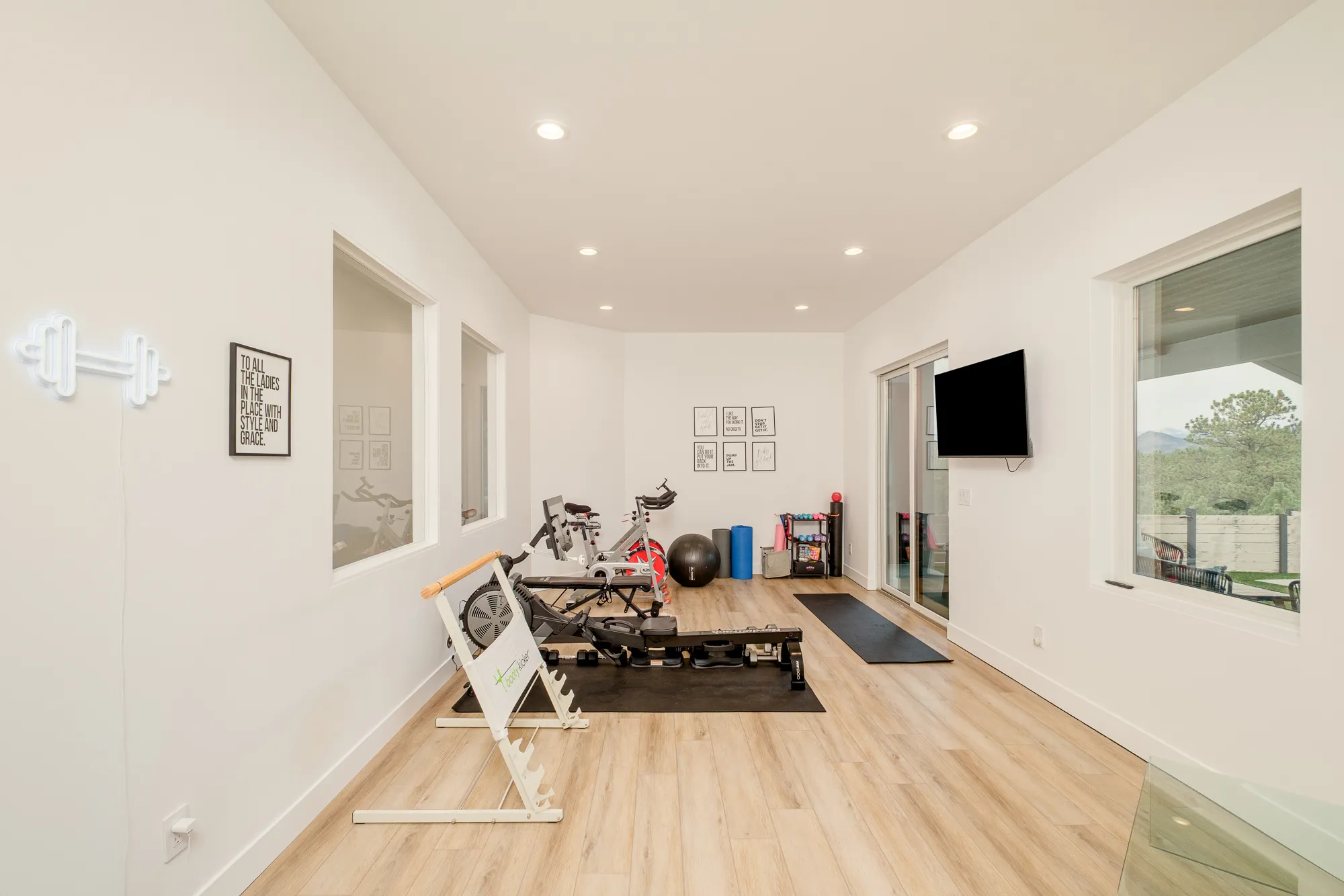 Home gym with a rowing machine and walkout windows