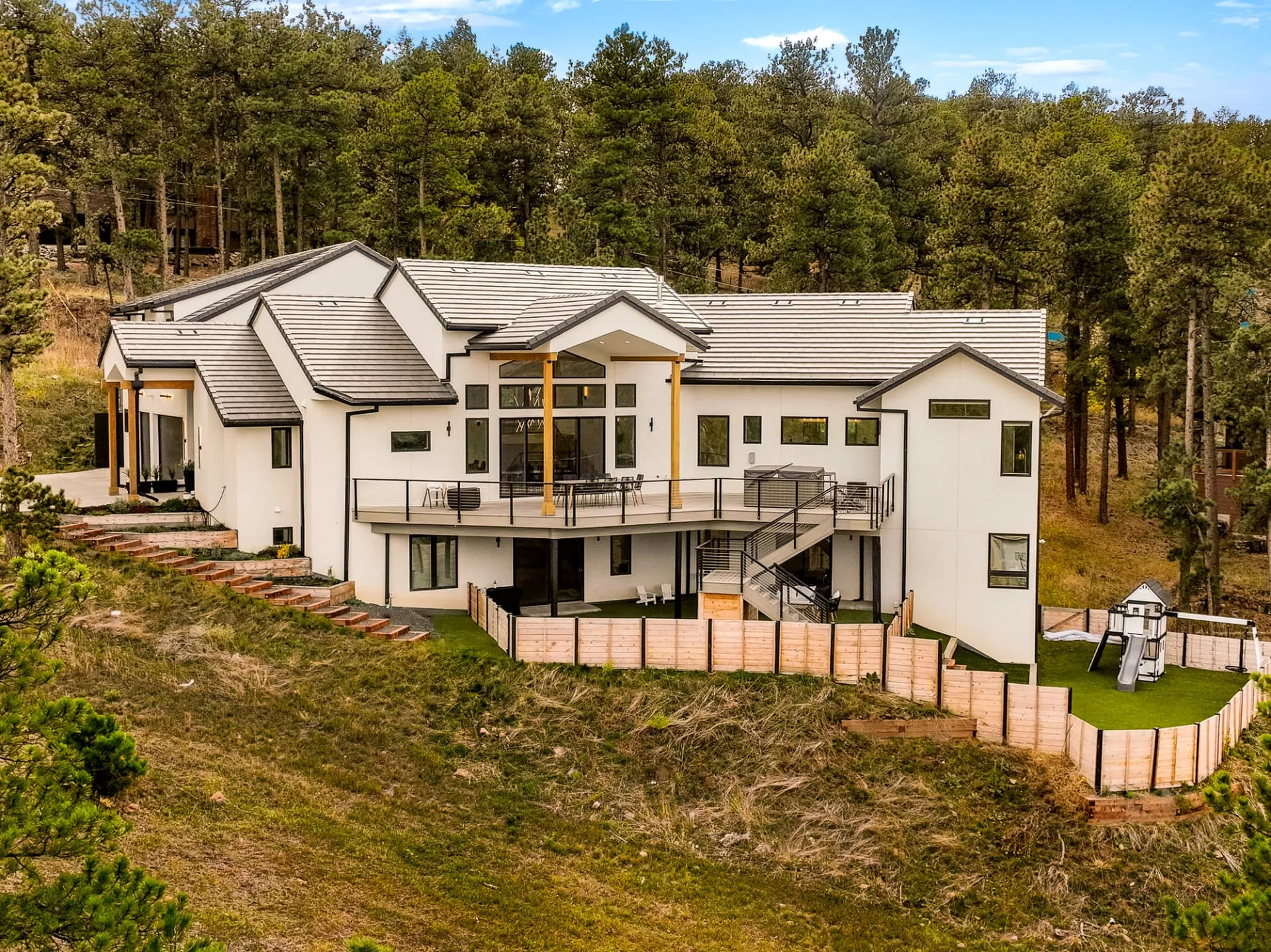 Aerial view of the rear elevation set into a pine forest