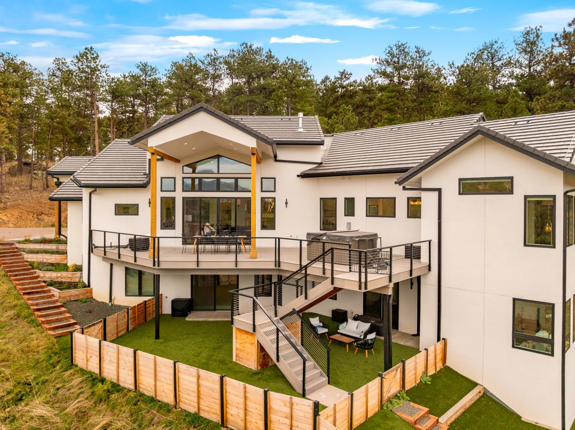Two levels of decks with cable railings above a terraced yard