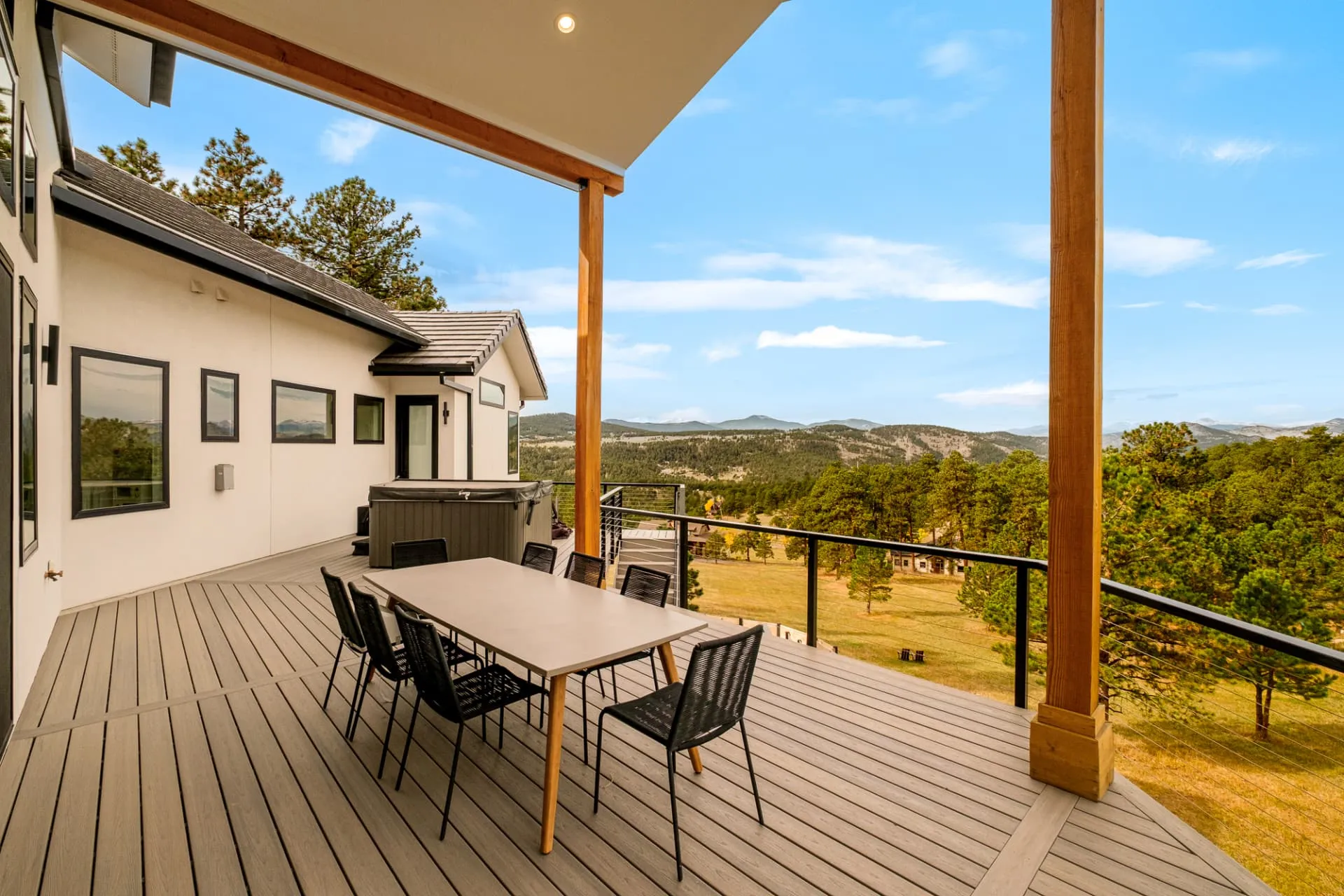 Covered deck with timber posts, dining table and foothills view