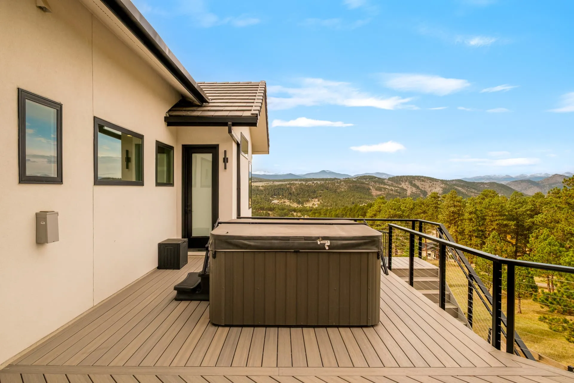 Upper deck with a hot tub overlooking the foothills