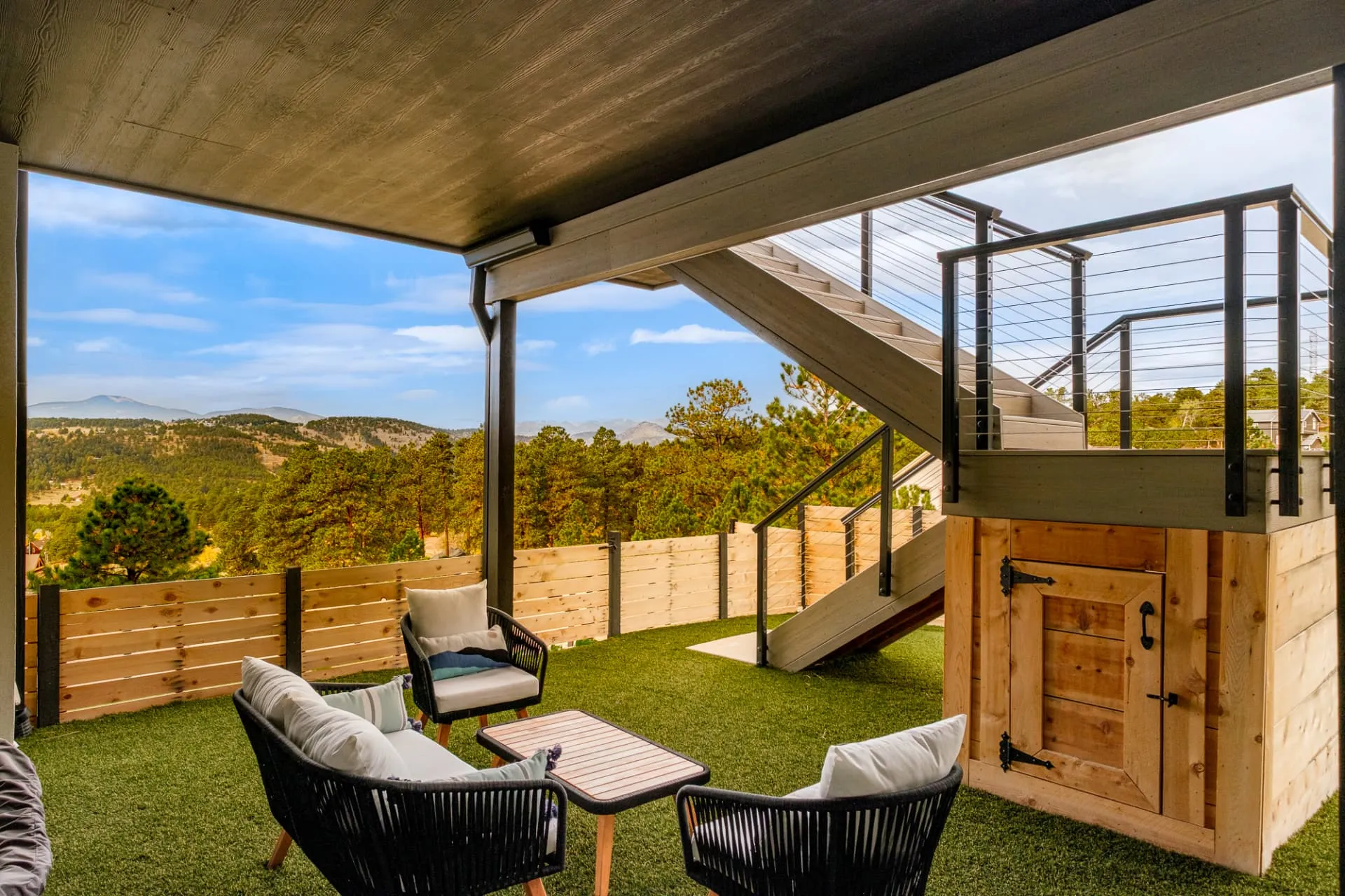 Covered lower patio with lounge chairs and turf yard