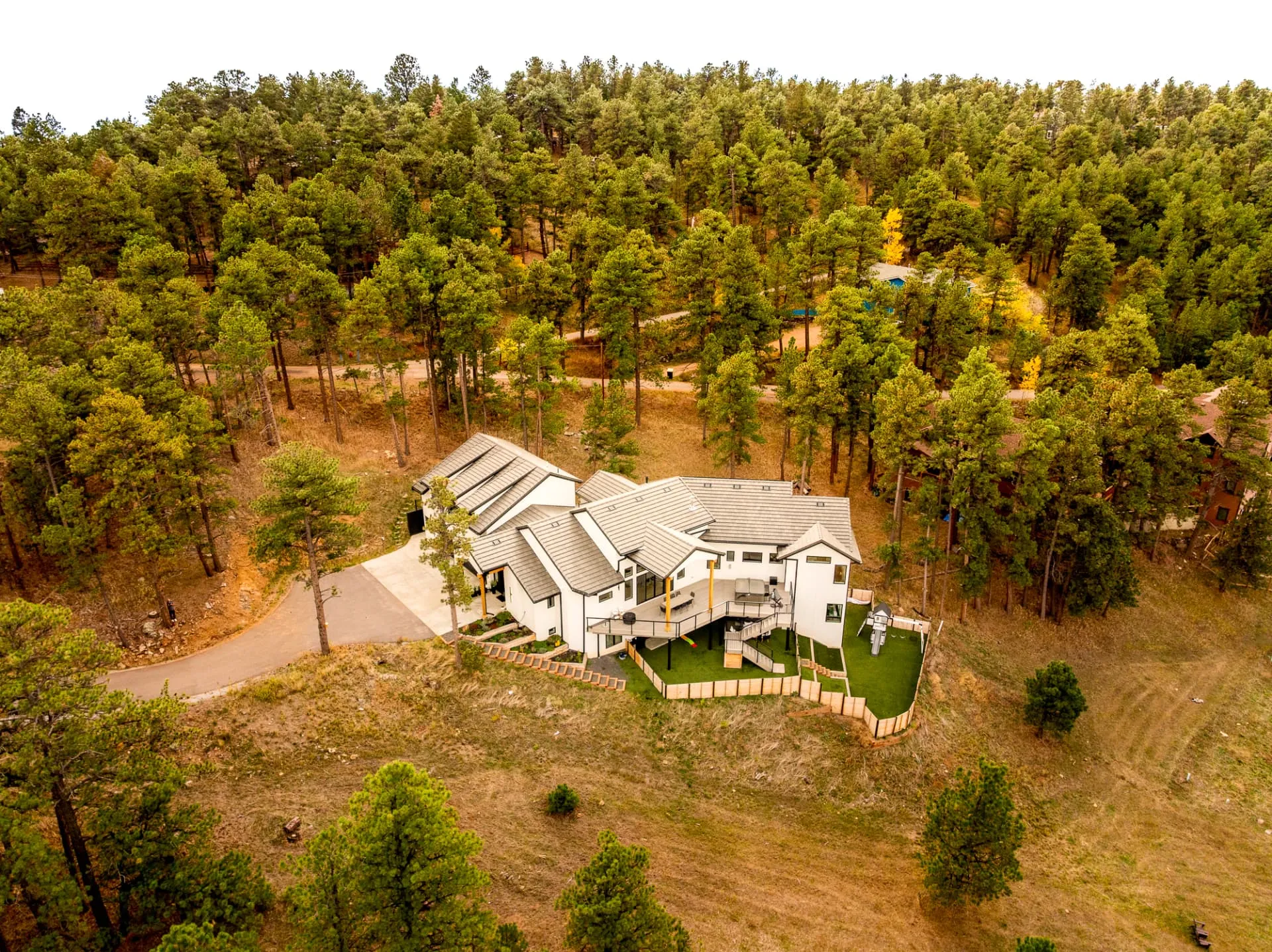 Overhead aerial view of the home within the surrounding forest